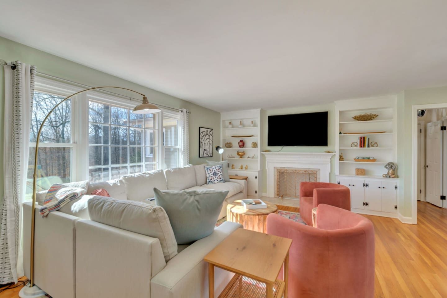 Una sala de estar con un sofá, sillones, una chimenea y un televisor.