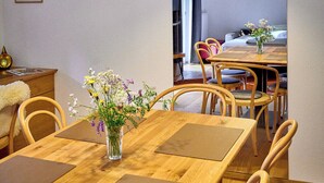 Un espace repas comprenant une table en bois, des chaises et un luminaire suspendu.