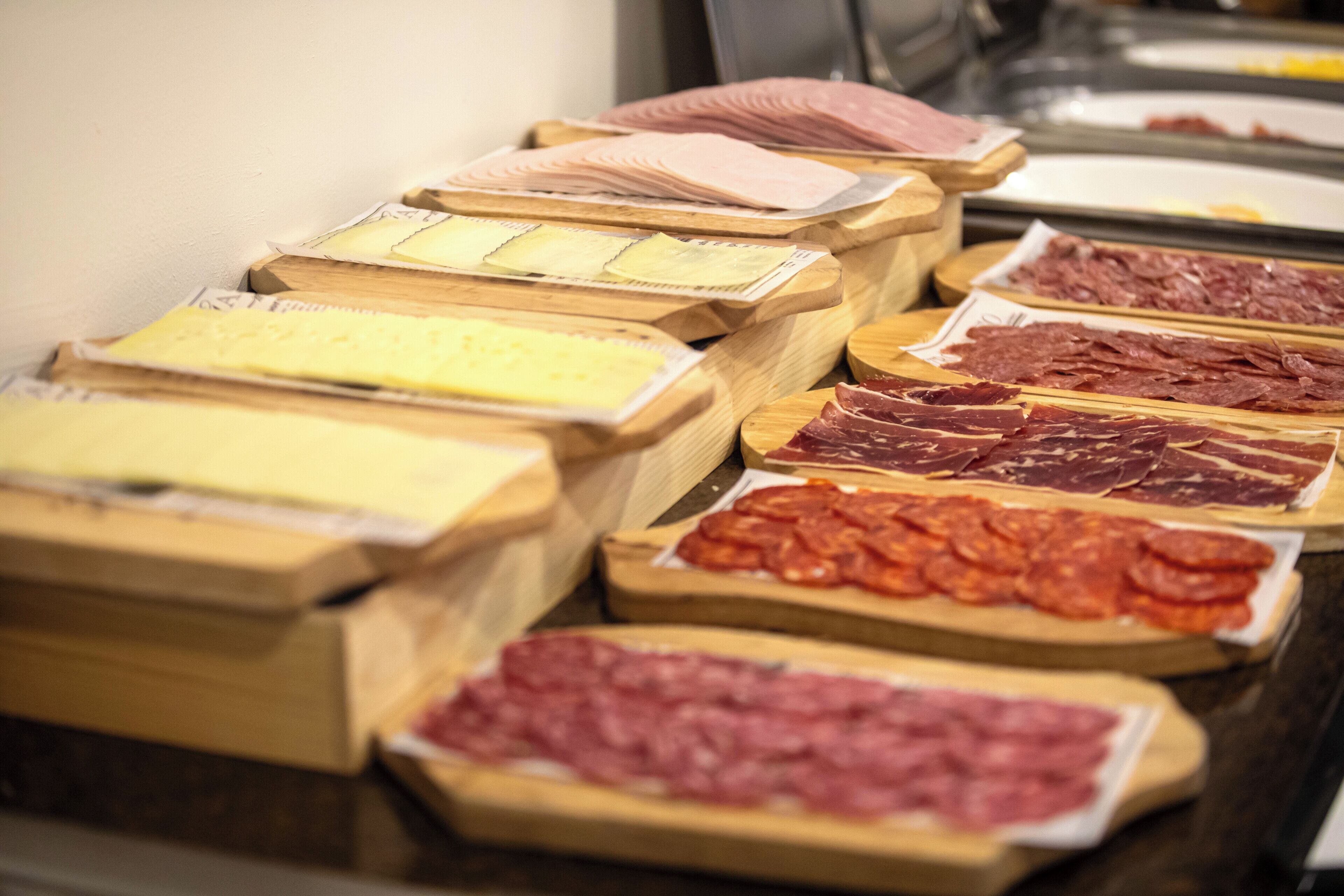 Diverse varietà di carne esposte su assi di legno.