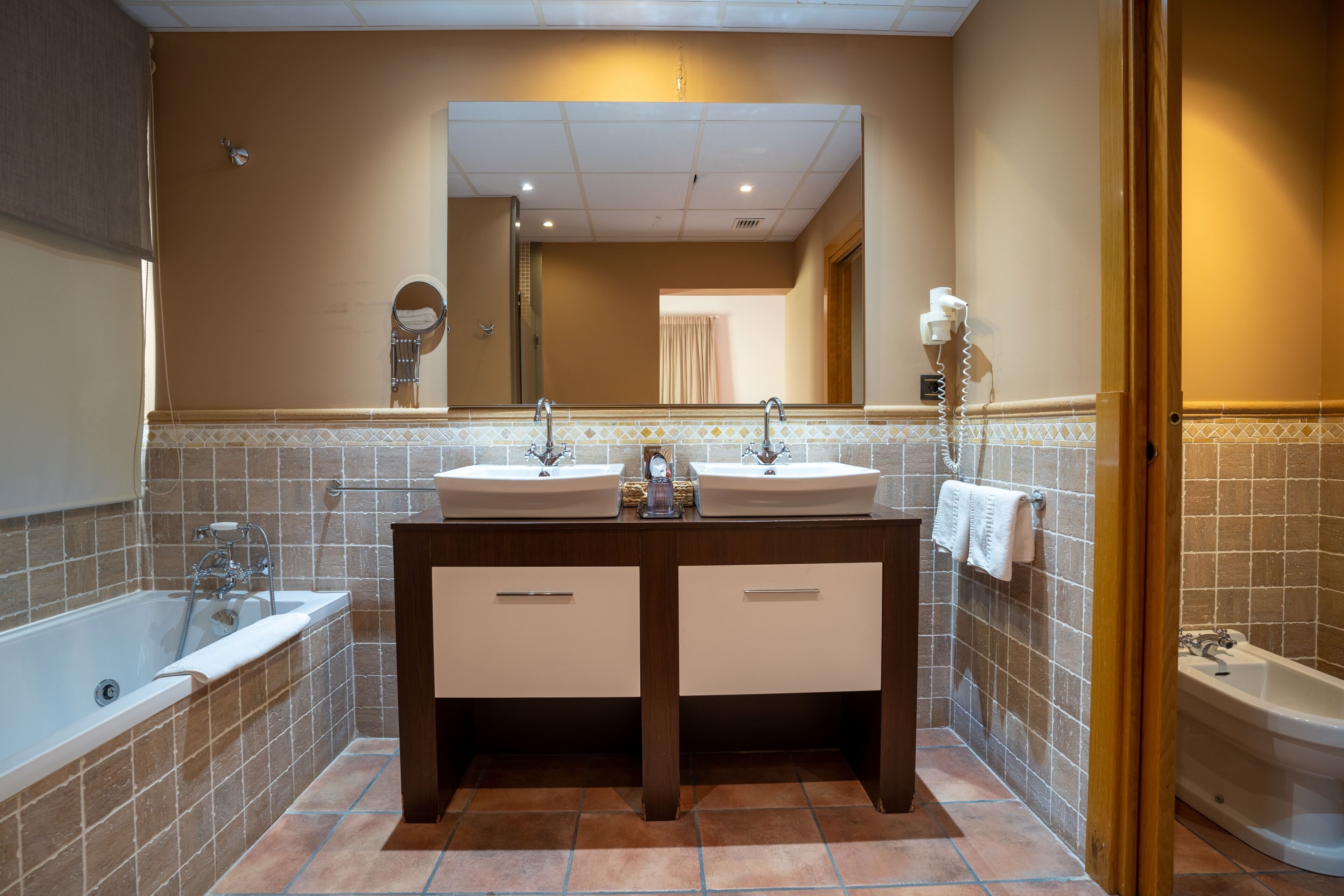 A bathroom with two sinks, a bathtub, and a shower.