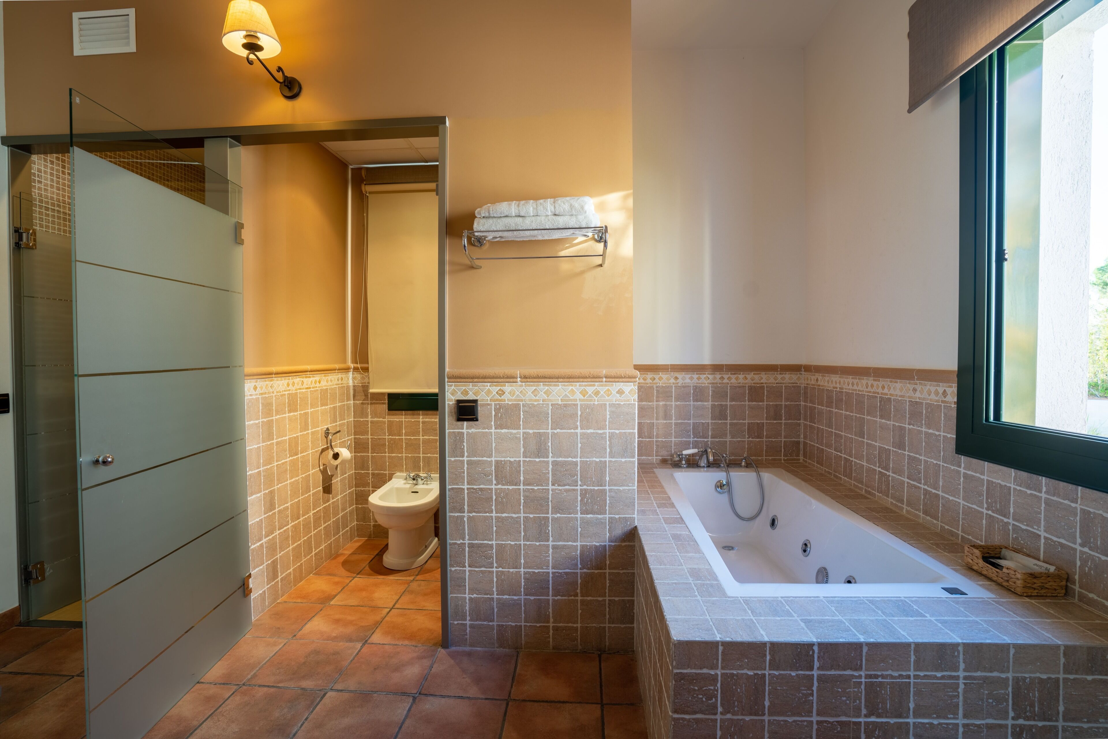 Une salle de bain équipée d’une baignoire, de toilettes et d’une douche à parois en verre.