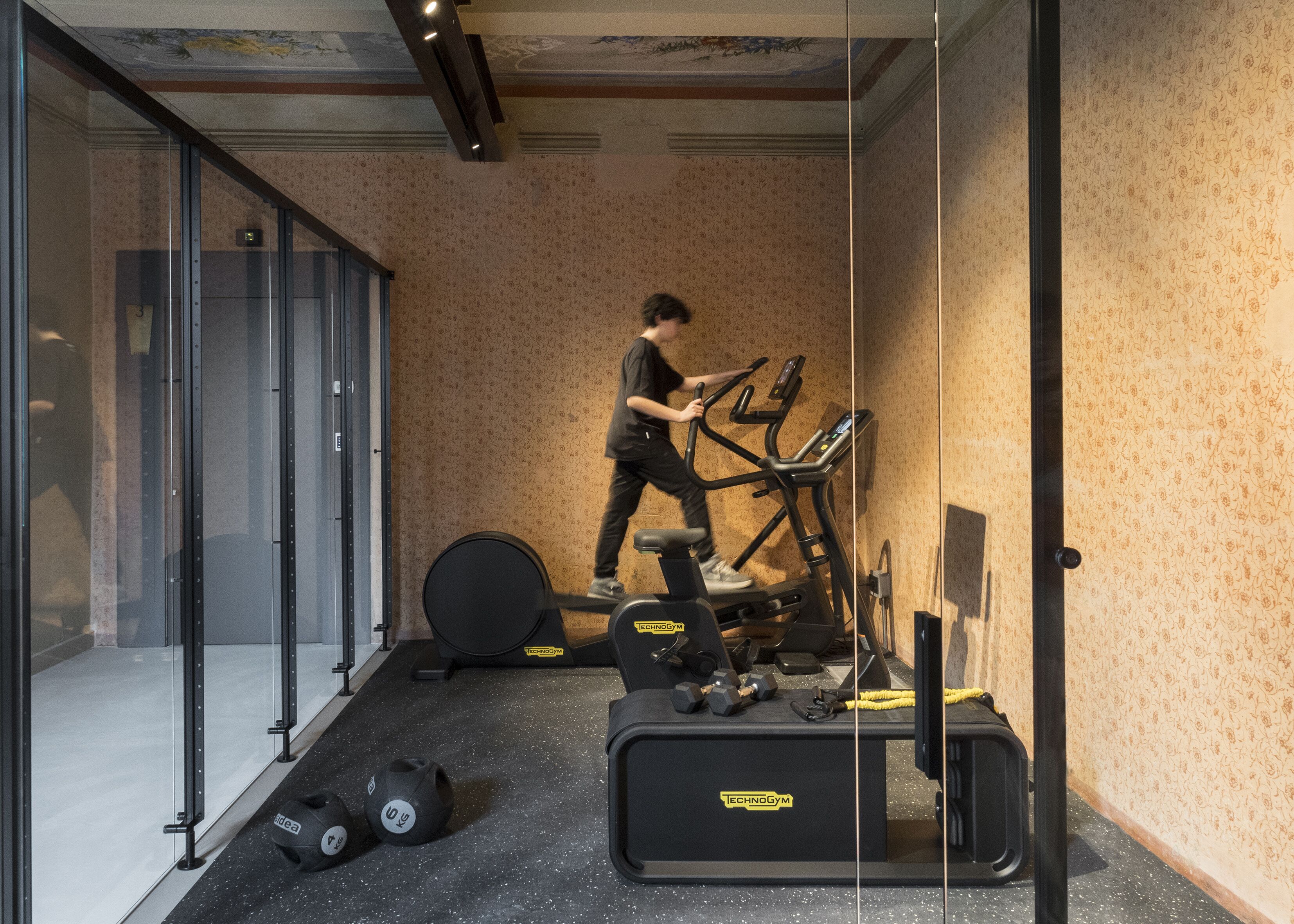A gym with a stationary bike, weights, and a treadmill.