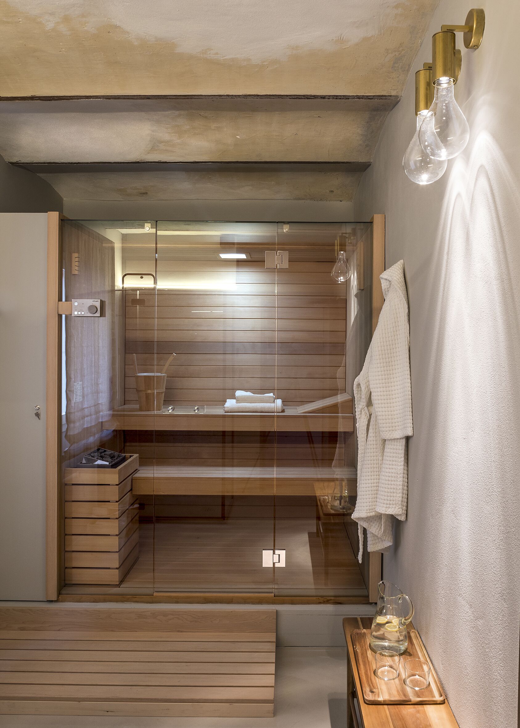 Un baño moderno con tocador de madera, cabina de ducha de vidrio y perchero.