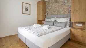 Un dormitorio con una cama, un armario de madera y un mapa en la pared.