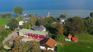 Un quartier résidentiel avec des maisons, un grand bâtiment rouge et une étendue d’eau en arrière-plan.