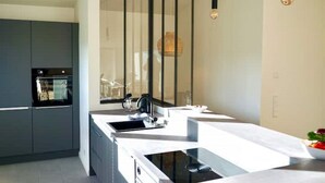 Une cuisine moderne dotée d’un four encastré, d’une grande fenêtre et d’un plan de travail élégant.