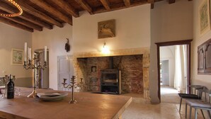 A rustic interior with exposed brick walls, a wooden ceiling, and a brick fireplace.