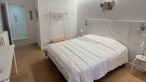 A bedroom with a bed, bedside table, and a hanging light fixture. - LE PETIT MONTY Gite Vue Étang 5 minutes from Puy Du Fou (Saint-Malô-du-Bois)