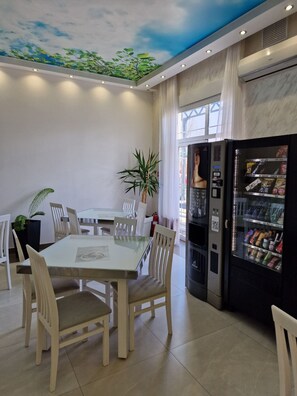 Enjoy meals in this dining area with a glass-top table and comfortable seating, surrounded by a beautiful mural.