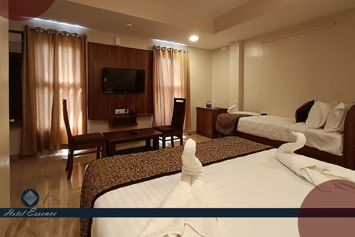 A hotel room with a bed, a desk, a chair, a television, and curtains.