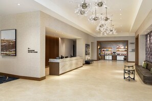 Un hall d’hôtel comprenant un comptoir d’accueil, un espace salon et une kitchenette.
