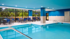 An indoor swimming pool with blue-tiled walls and a clear view of the outdoors through large windows. - Hampton Inn Towson Downtown (Towson)