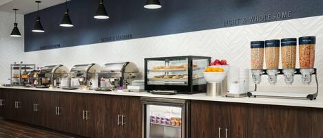 Ein Bereich mit Buffet und verschiedenen Speiseausgaben, darunter ein gekühlter Tresen und eine Kaffeestation.