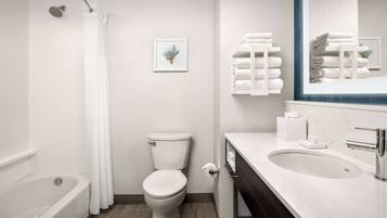 A modern bathroom with a bathtub, toilet, and sink.
