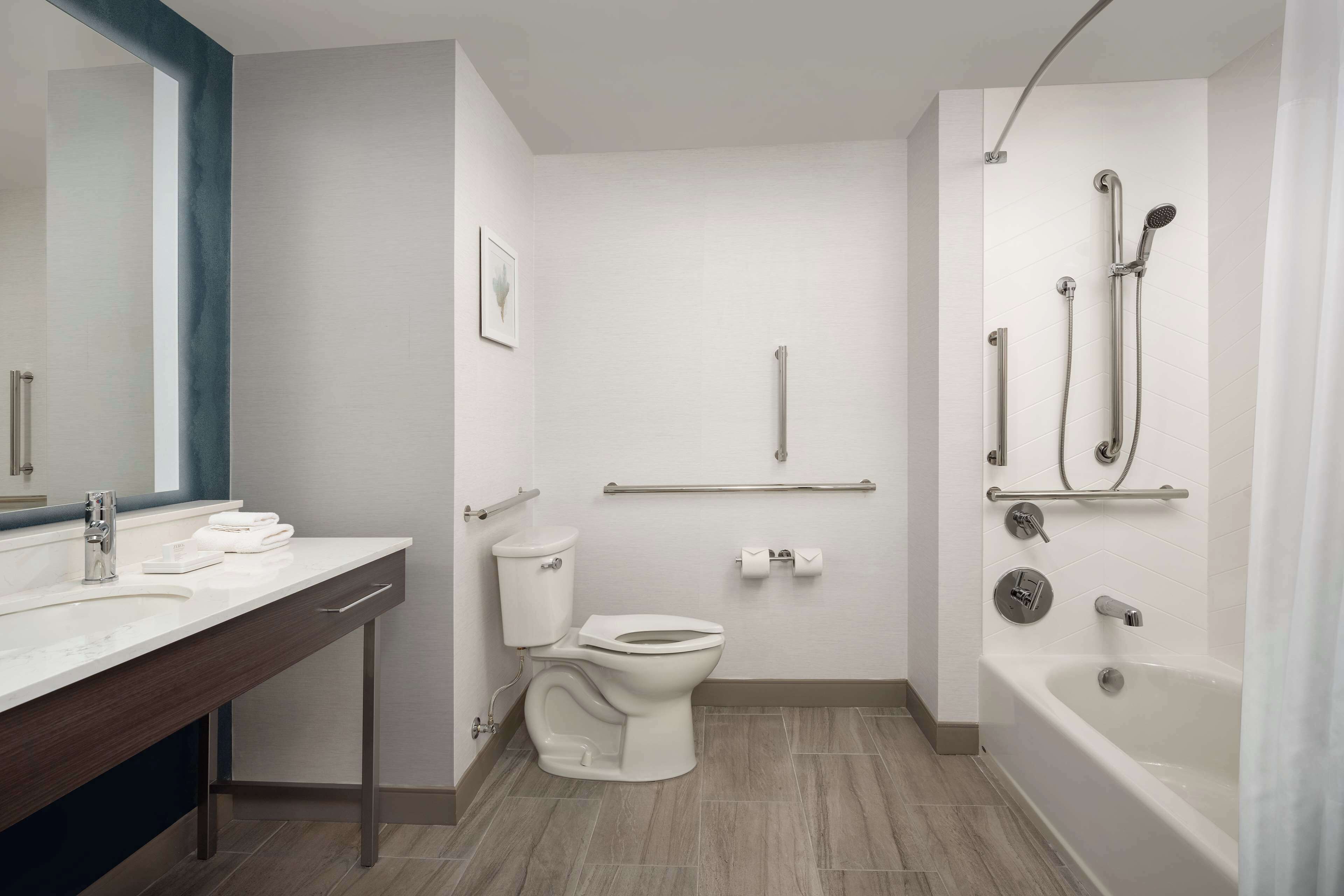 A modern bathroom with a toilet, sink, and bathtub.