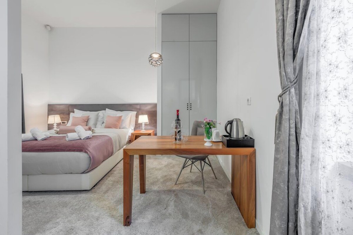 A modern bedroom with a bed, bedside table, lamp, and a wardrobe.