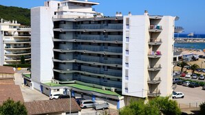 Un hôtel à plusieurs étages doté de balcons, d’un parking et offrant une vue sur la plage.