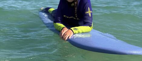 A person sitting on a surfboard in the water.
