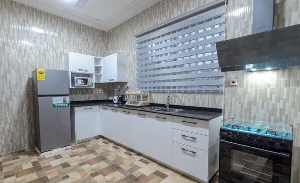 Enjoy cooking in this well-lit kitchen with a gas stove, microwave, and refrigerator.