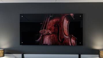A framed artwork of a violin on a dark wall.