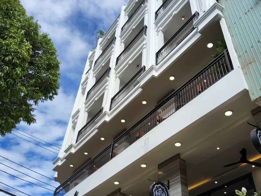 Un hôtel à plusieurs étages, doté de balcons et d’une enseigne indiquant qu’il s’agit d’un hôtel.