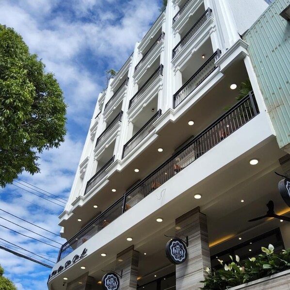 A multi-story hotel with balconies and a sign indicating it is a hotel.