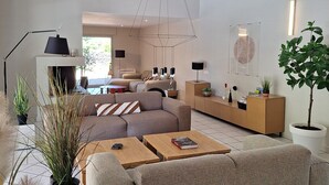 Una sala de estar moderna con sofá, mesa de centro y lámpara colgante.
