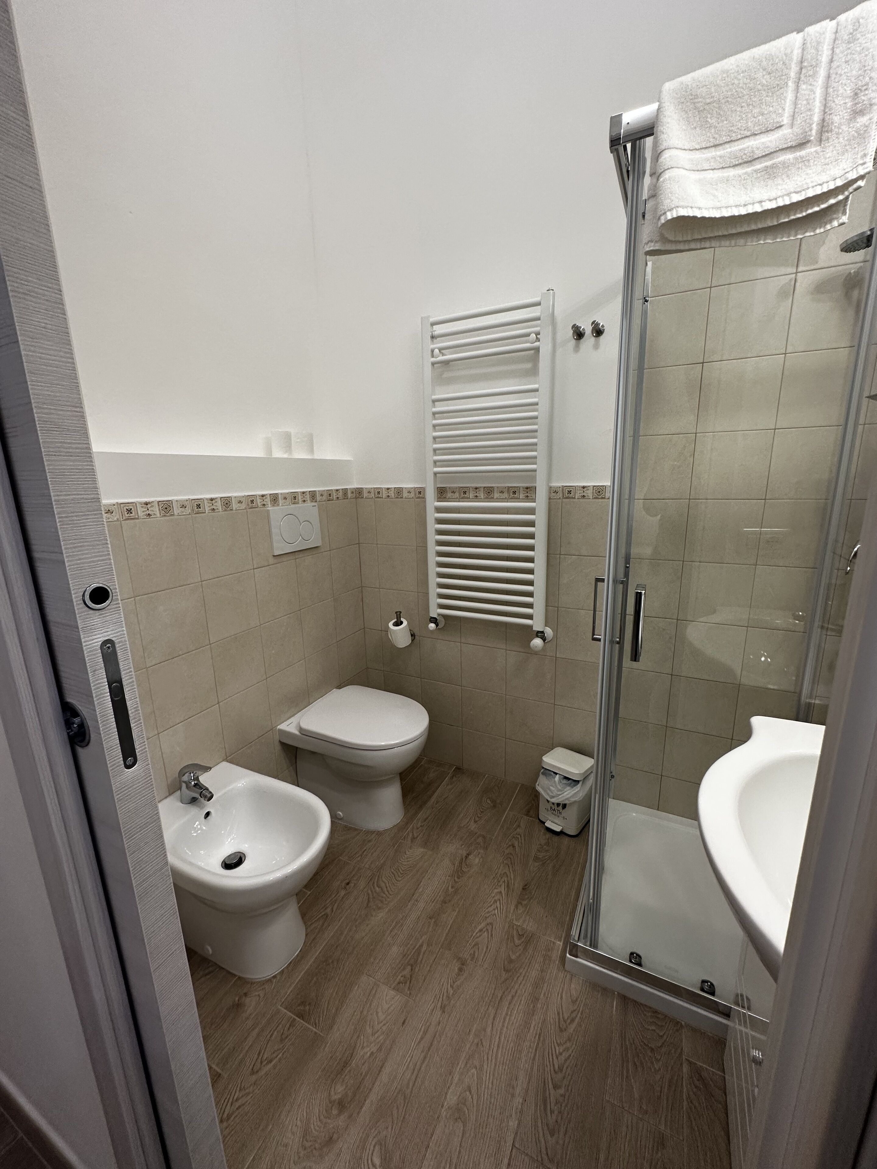 Ein Badezimmer mit Dusche, Toilette, Bidet und Waschbecken.
