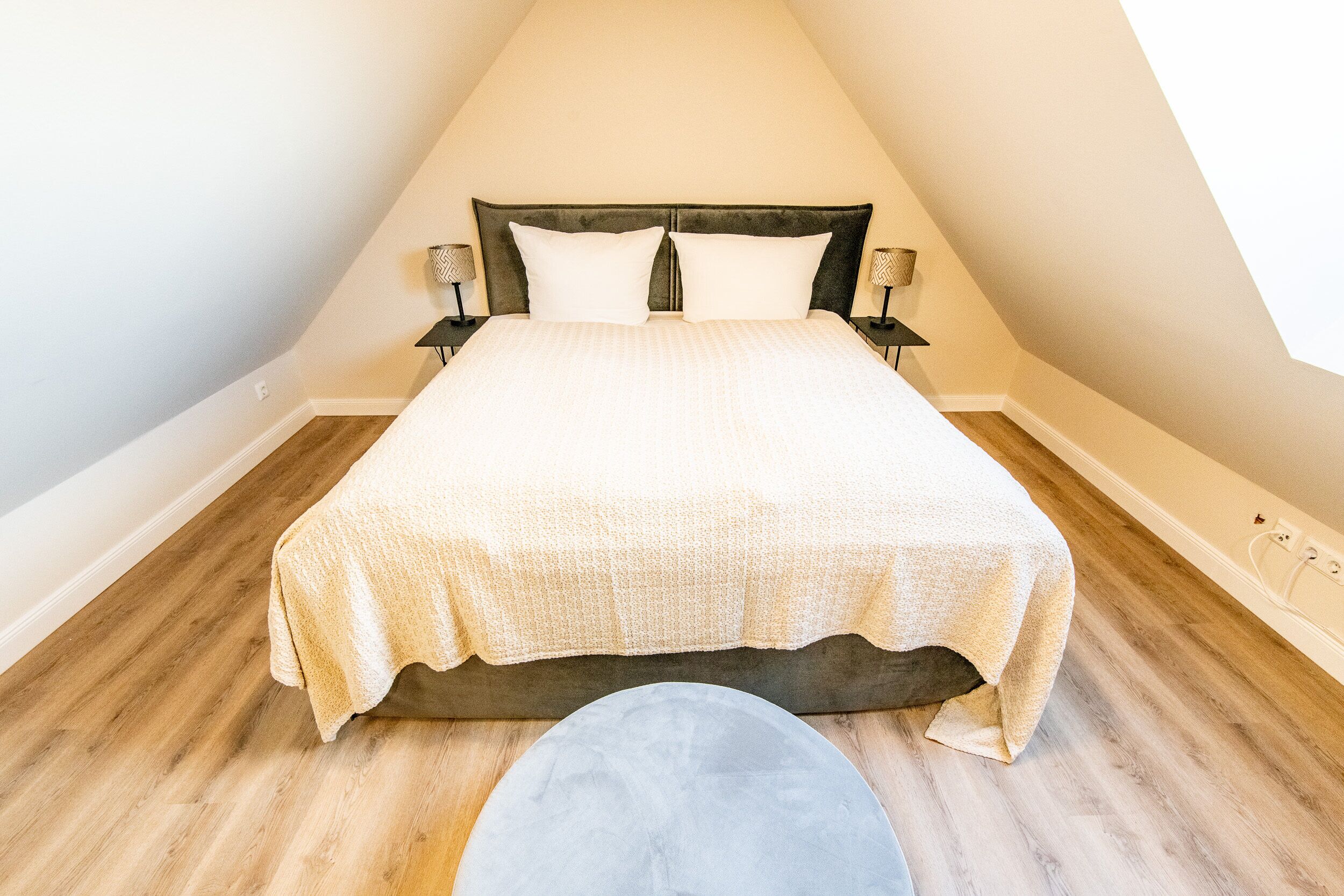 A bedroom with a bed, two bedside tables, and a nightstand.