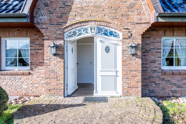 Classic brick building with a traditional arched entrance and a tiled roof.