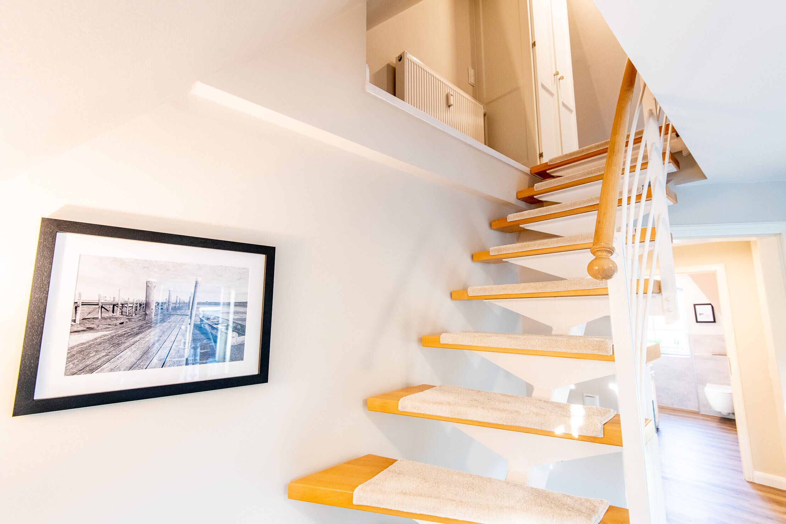 Eine Treppe mit Holzdielen und einer weißen Wand.