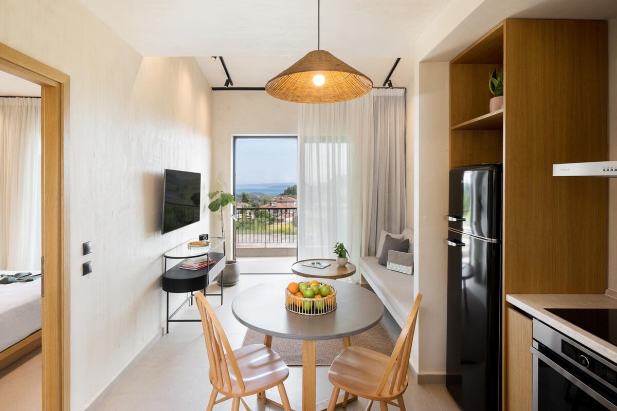 A compact kitchen with a dining area, a black refrigerator, and a view of the outdoors.