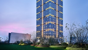 A high-rise building with a modern glass facade and illuminated horizontal lines. - Q-Box Hotel Shangqiu Expo Center (Shangqiu)