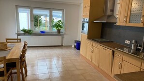 Una cocina moderna con armarios de madera, horno integrado y ventana con vistas a la vegetación.