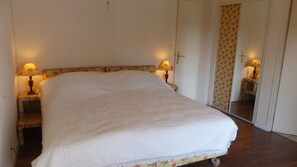 A bedroom with a large bed, two bedside lamps, a mirror, and a wardrobe. - DOLMEN -  Longère 7 pièces, Grand jardin - ST58 (Carnac)