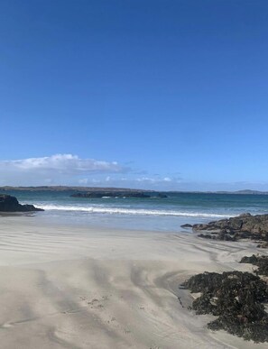 A beach with clear skies, calm waves, and rocky outcrops. - Dál Riada B&B (Carrick)