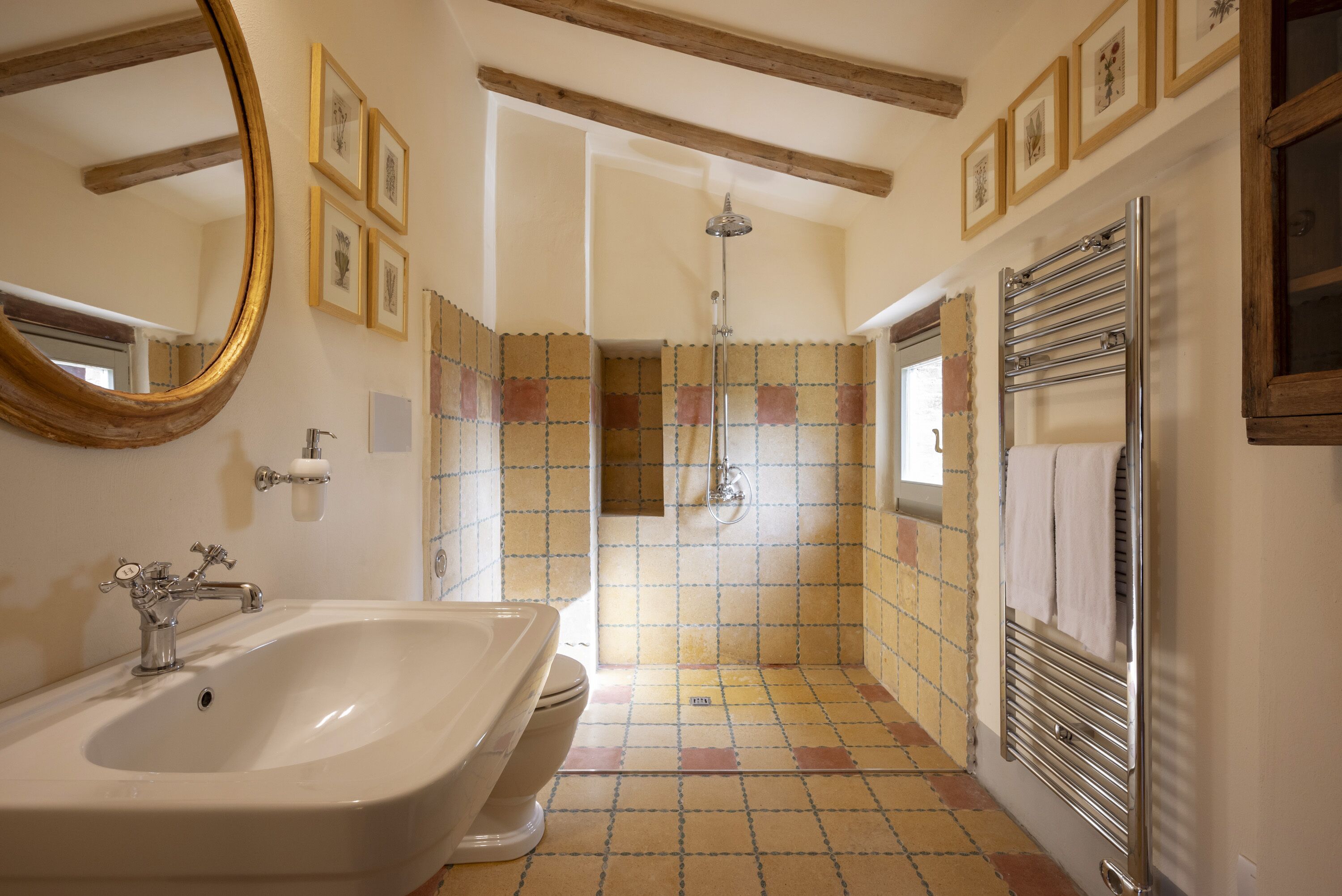 A bathroom with a large sink, a shower, and a towel rack.