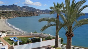Ein Pool mit Blick auf Strand und Berge.