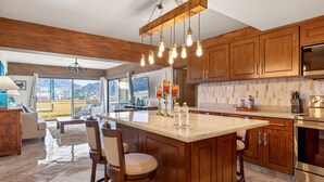 Une cuisine moderne avec des meubles en bois, un îlot central et une grande fenêtre donnant sur un paysage magnifique.