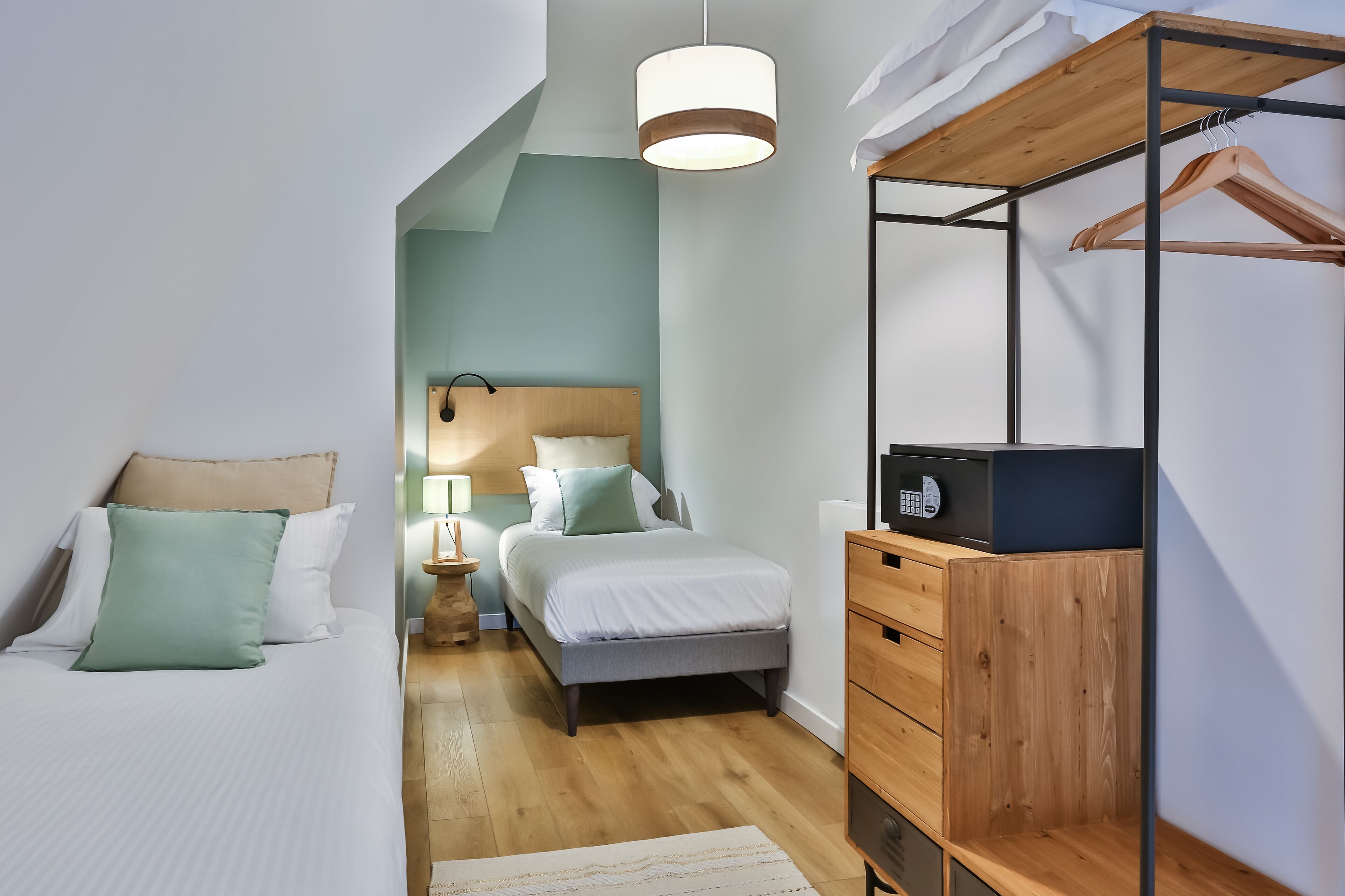 A modern bedroom with a bed, bedside table, lamp, and a wooden wardrobe.