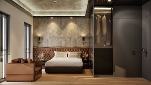 A modern bedroom with a large bed, a seating area, and a wardrobe.