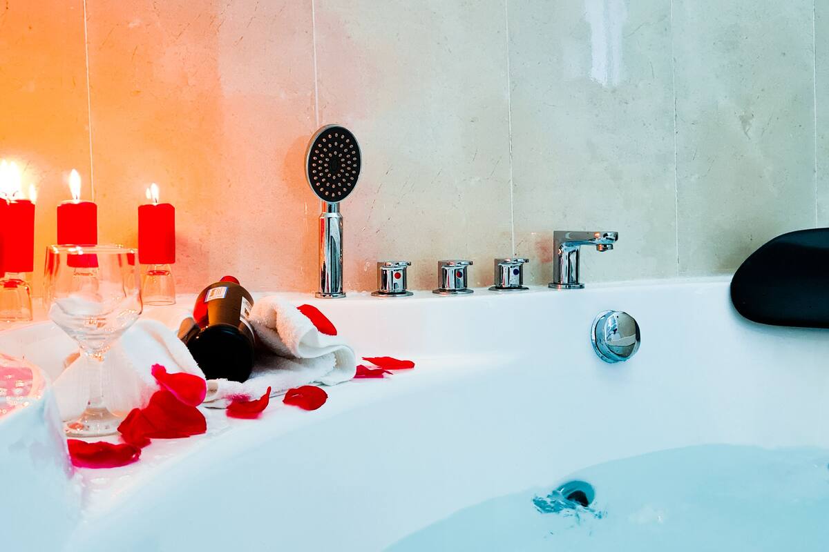 Un baño con bañera, ducha y tocador con espejo.