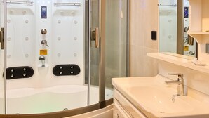 A modern bathroom with a glass-enclosed shower, a white sink, and a mirror.
