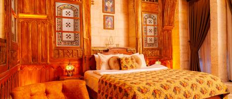 Un dormitorio tradicional con una cama grande, paneles de madera ornamentados y un candelabro.