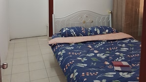 Un dormitorio con cama, armario, ventilador de techo y unidad de aire acondicionado.