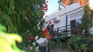 Un edificio con pared de ladrillo y baranda metálica.