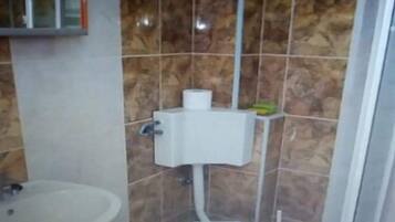 A bathroom with a toilet, bidet, and sink.