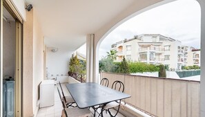 Enjoy dining or socializing on the balcony with a table and chairs overlooking a residential area.