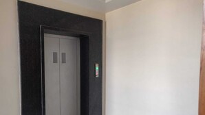 Un pasillo estrecho con una puerta que da a un ascensor.