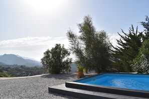 Una piscina con vistas a montañas y árboles.